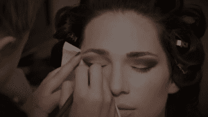 bride getting eye makeup for wedding by makeup artist